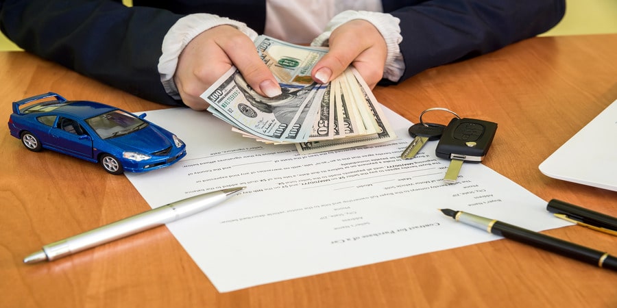 Taxfree RV illustrates Can a Montana LLC Write Off a Vehicle Purchase? with cash, keys, and a toy car, symbolizing business vehicle deductions.