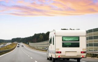 RV traveling on a highway at sunset