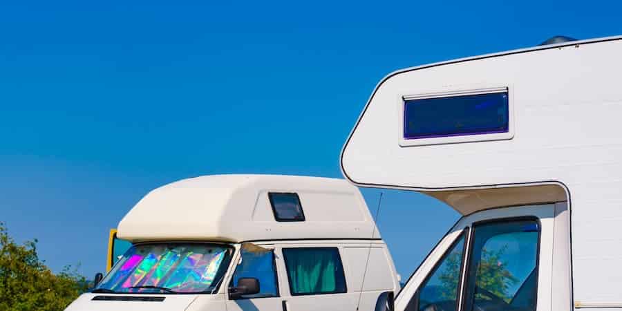 RV Cost of Ownership How Much it Really Costs to Own an RV Two camper vans under blue sky